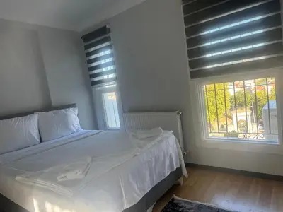 a bedroom with a white bed and two windows at Mehmet Paşa Konağı in Istanbul