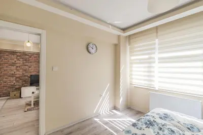 a bedroom with a bed and a clock on the wall at White Rose Apart in Istanbul