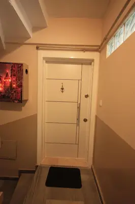 a hallway with a white door and a painting at White Rose Apart in Istanbul