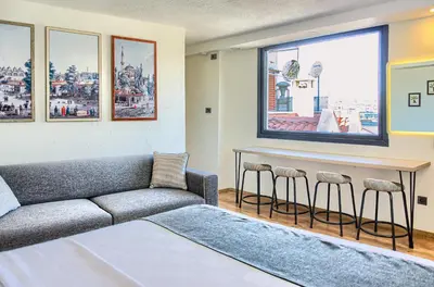 a living room with a couch and a bar with stools at Vita Otel in Istanbul
