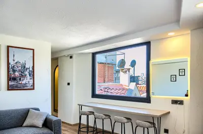 a living room with a table and a large window at Vita Otel in Istanbul
