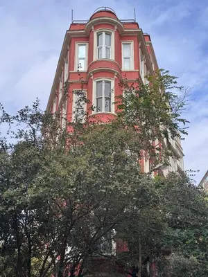 a red building with trees in front of it at High Garden Rooftop Terrace Apartment Around Galata Tower in Istanbul
