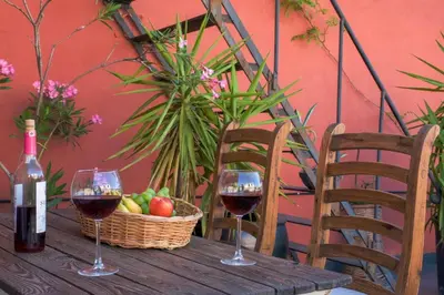 two glasses of wine and a basket of fruit on a wooden table at High Garden Rooftop Terrace Apartment Around Galata Tower in Istanbul