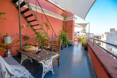 a balcony with a table and stairs on a building at High Garden Rooftop Terrace Apartment Around Galata Tower in Istanbul