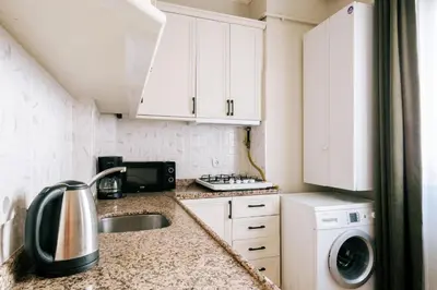 a small kitchen with white cabinets and a sink at Upscale Apartments w Balcony - Near Istiklal in Istanbul