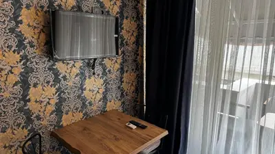 a room with a table and a tv on a wall at Tuzla Sahil Enjoy Hotel in Tuzla