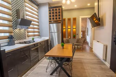a kitchen with a table and a refrigerator at Modern 2BR Flat 1min walk to Taksim square in Istanbul