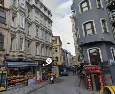 a man riding a motorcycle down a city street with buildings at Modern 2BR Flat 1min walk to Taksim square in Istanbul