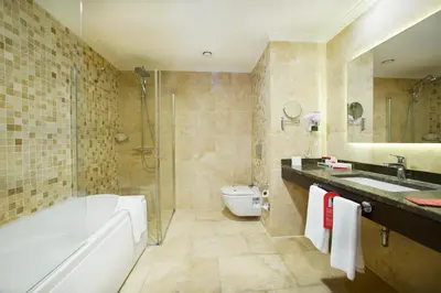 a bathroom with a tub and a toilet and a sink at Ramada by Wyndham Istanbul Merter in Istanbul