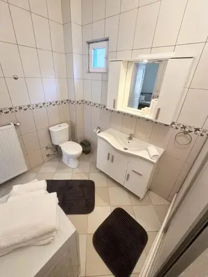 a white bathroom with a sink and a toilet at Garden House Heybeliada in Adalar