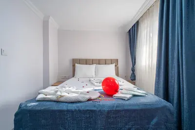 a bed with a red helmet and towels on it at Atakent Suite Hotel in Istanbul