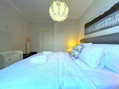 a large white bed in a bedroom with a chandelier at Taksim360 Residences in Istanbul