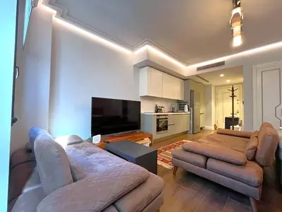 a living room with a couch and a flat screen tv at Taksim360 Residences in Istanbul