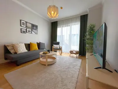 a living room with a couch and a flat screen tv at Taksim360 Residences in Istanbul