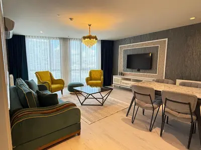 a living room with a table and chairs and a television at new luxury comfortable apartment in Istanbul