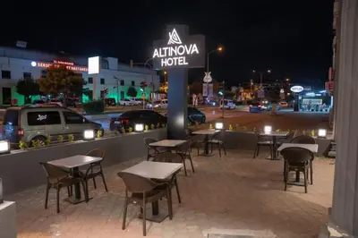 a group of tables and chairs on a street at night at Altınova Hotel Sakarya in Serdivan
