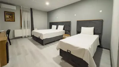 a hotel room with two beds with white sheets at Altınova Hotel Sakarya in Serdivan