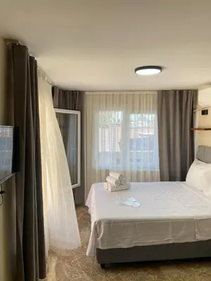 a hotel room with a bed and a window at Büyükada Çarşı Pansiyon in Adalar