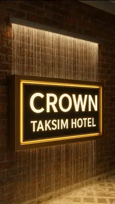 a sign on a brick wall with a crown takeaways hotel at crown taksim hotel in Istanbul