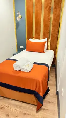 a bedroom with two beds with orange and white sheets at crown taksim hotel in Istanbul