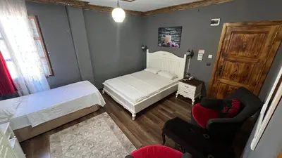 a small bedroom with a bed and a chair at La Fontaine Otel in Mudanya