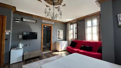a living room with a red couch and a tv at La Fontaine Otel in Mudanya