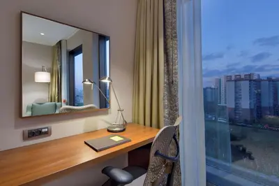 a hotel room with a desk and a mirror at Hilton Garden Inn Istanbul Beylikduzu in Istanbul