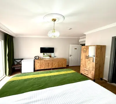 a bedroom with a bed and a television and a refrigerator at Armagan Home Taksim in Istanbul