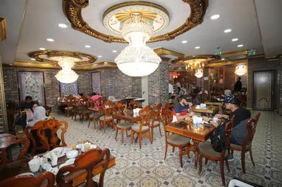 a dining room with people sitting at tables in a restaurant at Laleli Blue Marmaray Hotel in Istanbul