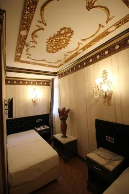 a bedroom with two beds and a gold ceiling at Laleli Blue Marmaray Hotel in Istanbul
