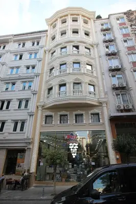 a large white building with balconies on a street at Laleli Blue Marmaray Hotel in Istanbul