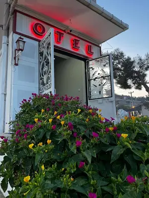 a sign on a building with flowers in front of it at Kumbağ Otel in Kumbağ