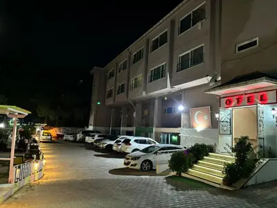 a parking lot in front of a hotel at night at Kumbağ Otel in Kumbağ