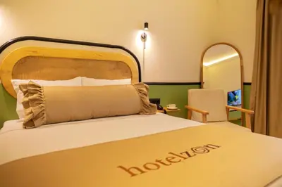 a hotel room with a large bed and a chair at Hotel Zon in Serdivan