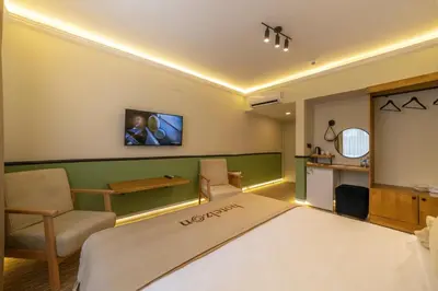 a room with a bed and a chair and a table at Hotel Zon in Serdivan