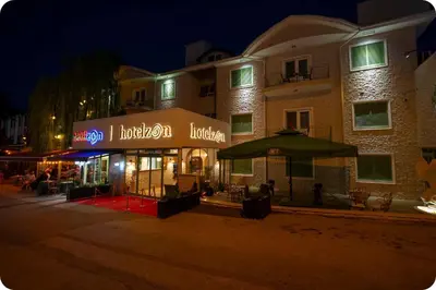 a building with a restaurant in front of it at night at Hotel Zon in Serdivan