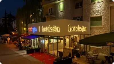 a restaurant with a sign on the side of a building at Hotel Zon in Serdivan