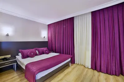 a bedroom with purple curtains and a large bed at The Hera Premium Hotels in Istanbul