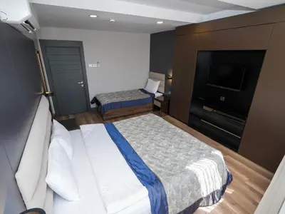 a hotel room with two beds and a flat screen tv at No 139 Apartments in Istanbul
