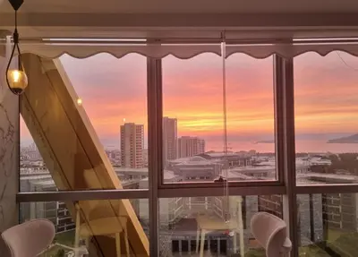 a window with a view of a city at sunset at Dap Vazo Kule Rezidansta Konaklama Hizmeti in Istanbul