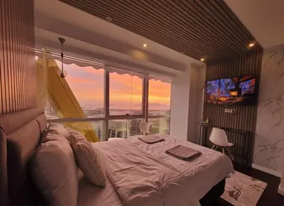 a bedroom with a bed and a large window at Dap Vazo Kule Rezidansta Konaklama Hizmeti in Istanbul
