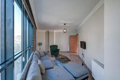 a living room with a large couch and a window at Par Konaklama in Istanbul