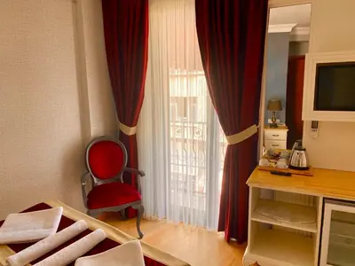 a room with a red chair in front of a window at Santefe Hotel in Istanbul