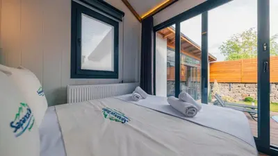 a bed in a room with a large window at The Now Sapanca Suites in Sapanca