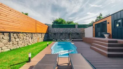 a backyard with a swimming pool and a stone wall at The Now Sapanca Suites in Sapanca