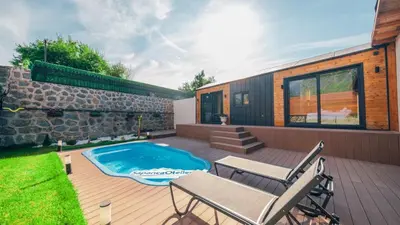 a backyard with a swimming pool and a house at The Now Sapanca Suites in Sapanca