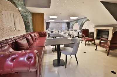 a restaurant with leather furniture and tables and a fireplace at Istanbul Taksim Pera Star Hotel - Istiklal Street in Istanbul