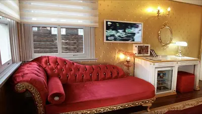 a red couch in a room with a fireplace at Sultan Suites Hotel in Istanbul