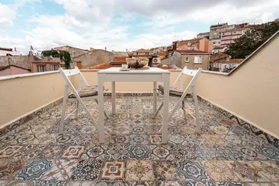 a balcony with a table and chairs on a tile floor at Mercan Apartments Balat-The Hidden Terrace in Istanbul