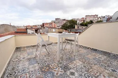 a patio with a table and chairs on a balcony at Mercan Apartments Balat-The Hidden Terrace in Istanbul